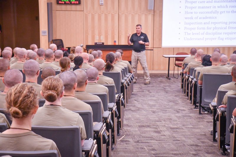 Capt. Jamie McGrath ’90 stands in front of a classroom of upper-class cadets during a training session in McBryde 100.